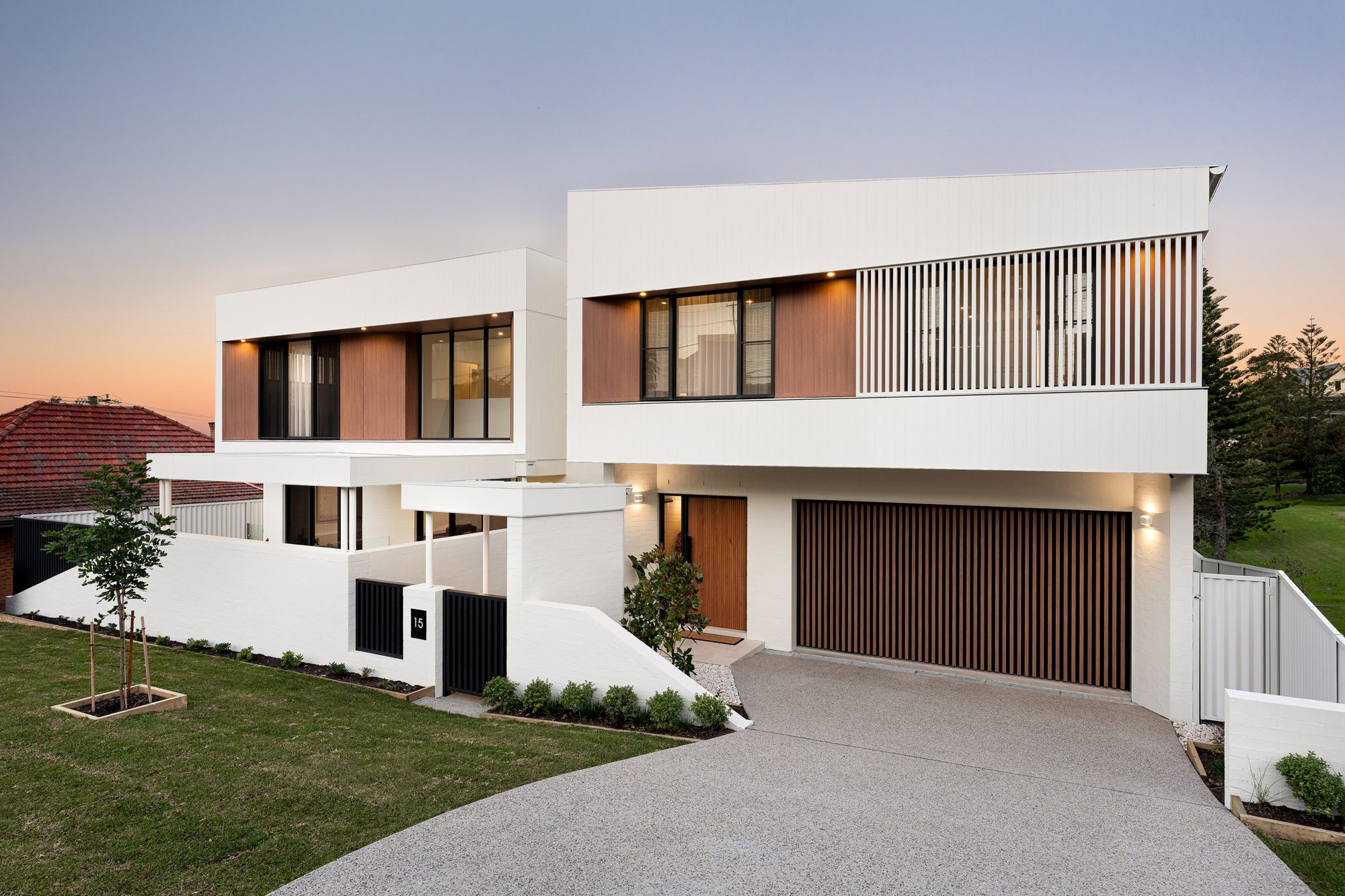 Rowan Crescent Merewether — dusk front facade with white cladding and timber slats